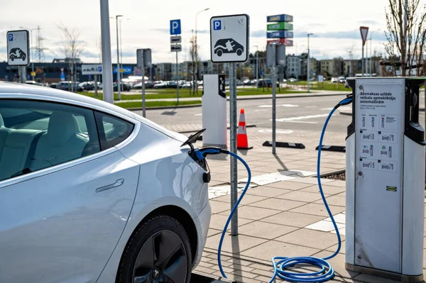 Riga, Letonya, 29 Nisan 2022: elektrikli otomobil Tesla Model S Dual Motor süpermarketin açık otoparkındaki şarj istasyonunda