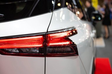 Modern bir arabanın kırmızı lambasına yakın çekim, arabanın arka lambasındaki detay...