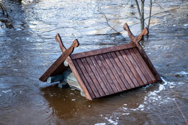 Bahar sellerinde taşan bir kuş evinin çatısına. Letonya, Dobele 'deki Berze Nehri' nde bir besleyici.