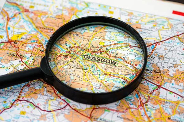 map of Glasgow in Scotland through magnifying glass, concept of planning the travel itinerary