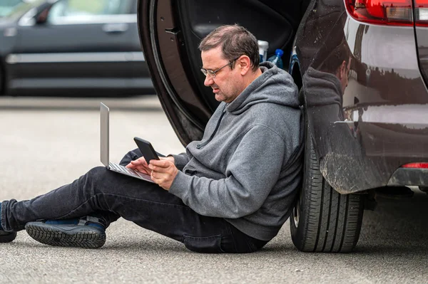 Hombre Mediana Edad Sentado Asfalto Junto Coche Trabajando Ordenador Portátil —  Fotos de Stock