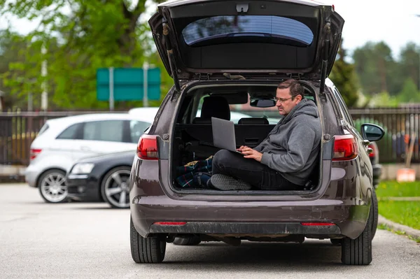 Ein Mann Sitzt Offenen Kofferraum Eines Autos Und Arbeitet Einem — Stockfoto