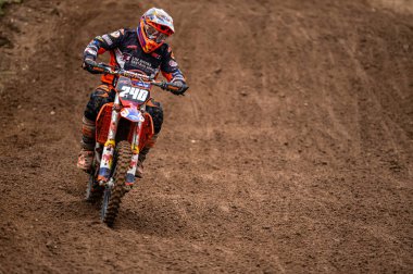 Dobele, Letonya, 18 Haziran 2022: Motokros sürücüsü toprak yol ve tepe arazileri boyunca hareket halinde, motokros şampiyonası