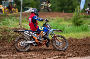 Dobele, Letonya, 18 Haziran 2022: Motokros sürücüsü toprak yol ve tepe arazileri boyunca hareket halinde, motokros şampiyonası