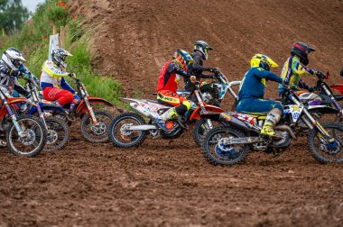 Dobele, Letonya, 18 Haziran 2022 toprak yol ve tepe arazileri boyunca hareket halindeki bir grup motokros sürücüsü, motokros şampiyonası.