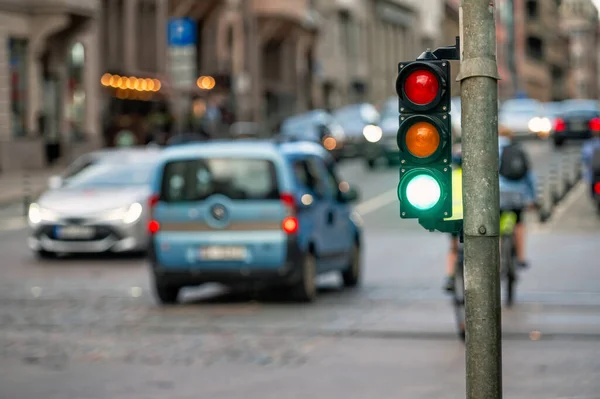 a city crossing with a semaphore on blurred background with cars in the evening streets, green light