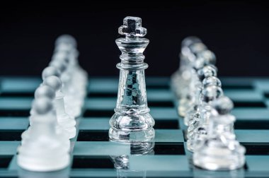 Transparent glass chess pieces on dark background. Leadership ,confrontation and  strategy concept