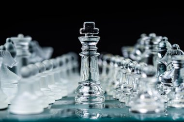 Transparent glass chess pieces on dark background. Leadership ,confrontation and  strategy concept