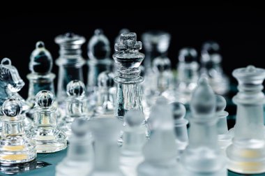 Transparent glass chess pieces on dark background. Leadership ,confrontation and  strategy concept