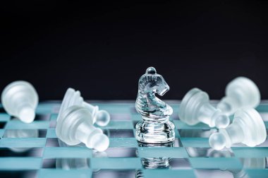 transparent glass chess on dark background, selective focus on knight piece, close-up