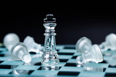 glass chess board game in black background ,selective focus on King, leadership ,winner concept