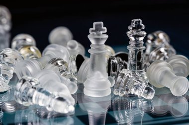 glass chess board game in black background ,selective focus on King, leadership ,winner concept