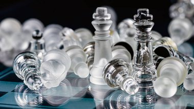 glass chess board game in black background ,selective focus on King, leadership ,winner concept