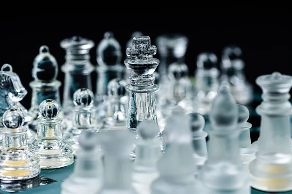 Transparent glass chess pieces on dark background. Leadership ,confrontation and  strategy concept
