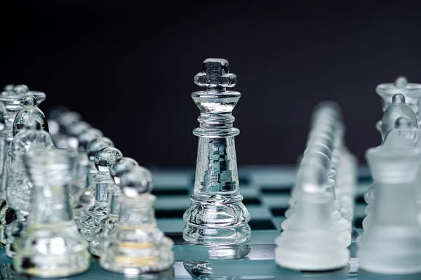 Transparent glass chess pieces on dark background. Leadership ,confrontation and  strategy concept