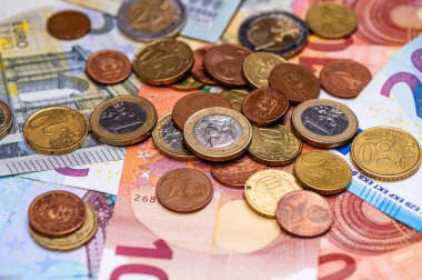 background of banknotes and euro coins of different denominations close-up
