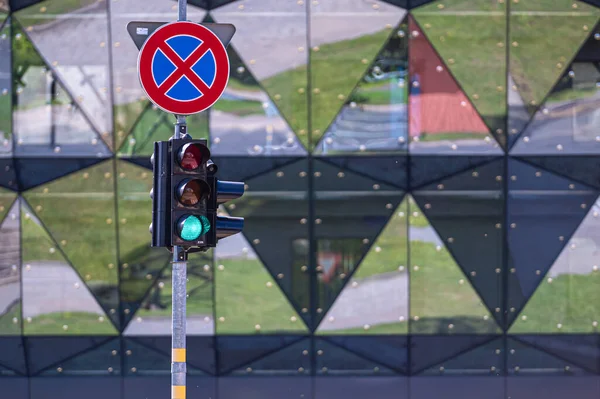 the traffic sign and semaphore with red light on the urban background, closeup