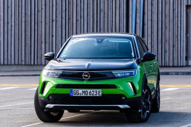 Riga, Letonya - 26 Mart 2021: yeşil elektrikli araç Opel Mokka-e halka açık otoparkta, geleceğin teknolojileri, modern tasarım