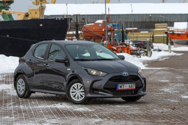 Riga, Letonya - 9 Şubat 2021: Metalik gri Toyota Yaris Hybrid Y20 model araba endüstriyel arka planda