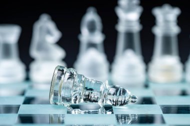 clear glass, transparent chess pieces on a checkerboard, selective focus, closeup, isolated on black
