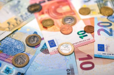background of banknotes and euro coins of different denominations close-up