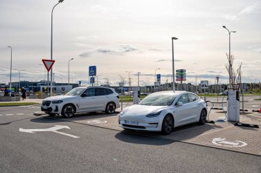 Riga, Letonya, 29 Nisan 2022: Süpermarketteki şarj istasyonundaki elektrikli arabalar Tesla Model S ve BMW ix3