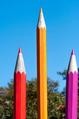 Odaklanamayan arka planda büyük dekoratif ahşap kalemler, okul konseptine geri dönüş.