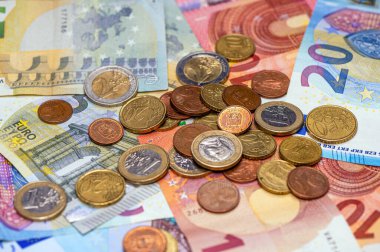 background of banknotes and euro coins of different denominations close-up