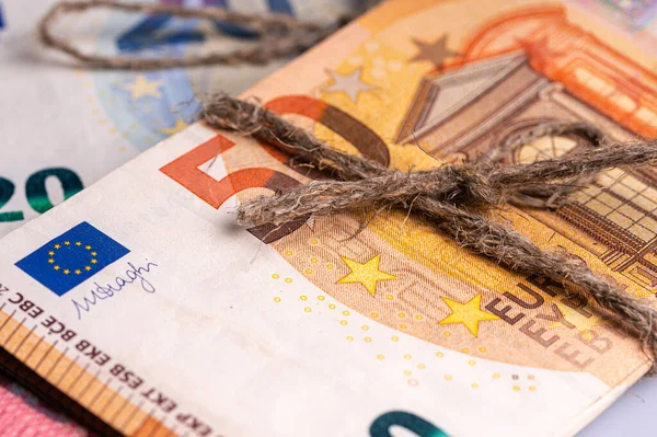 stack of euro banknotes tied with burlap string, closeup, wealth and prosperity concept