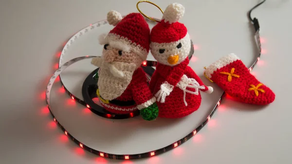 Crochet christmas snowman on white background with usb led lights on the scroll, flashing and static red, blue, green, yellow, synonymous with happy and warm christmas with children and loved ones — Stock Photo, Image
