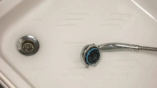 洗澡间的水从水龙头和淋浴器里漏出，水滴不停地往下流 — 图库照片