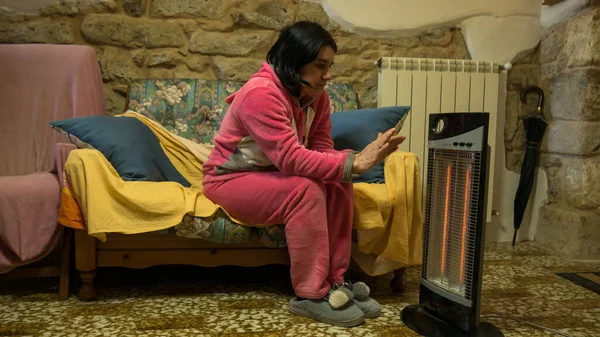 Evdeki kanepede pembe pijamalı hoş, serin bir kadın elektrikli ısıtıcının önünde ellerini ve ayaklarını ısıtıyor. Evimin sıcaklığında titriyordum..