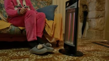 Evdeki kanepede pembe pijamalı hoş, serin bir kadın elektrikli ısıtıcının önünde ellerini ve ayaklarını ısıtıyor. Evimin sıcaklığında titriyordum..