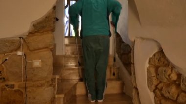 Evin merdivenlerinden koltuk değnekleriyle düşen yaşlı bir adam koltuk değneklerine takılıp yere düşerek dengesini kaybediyor. iç yaralanma.