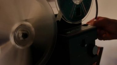 Antik 8mm süper projektör, bobinler dönüyor ve projektör ışığı açık.