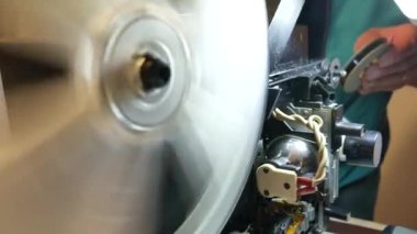 Antik 8mm süper projektör, bobinler dönüyor ve projektör ışığı açık.