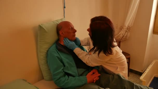 Domácí lékařské vyšetření s ženskou lékařkou, která navštíví staršího muže pacienta, zakrytí hrudníku, kontrola lymfatických uzlin. — Stock video