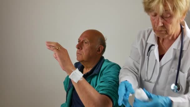 Złamania w kończynach. lekarz, który sprawdza, traktuje, owija pacjenta w głowę i kończyny na uraz z bandaży i gazy — Wideo stockowe