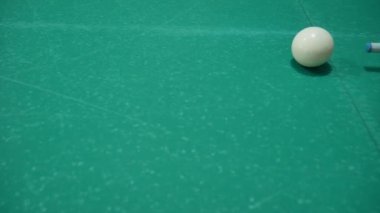 Renkli ve numaralandırılmış topları olan bilardo oyunu. Sekiz numara. Yeşil masa ve bilardo ıstakalı hareket eden toplar. Beyaz topu çeviriyor.. 