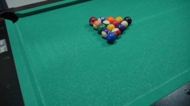 Renkli ve numaralandırılmış topları olan bilardo oyunu. Sekiz numara. Yeşil masa ve bilardo ıstakalı hareket eden toplar. Beyaz topu çeviriyor.. 