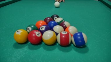 Renkli ve numaralandırılmış topları olan bilardo oyunu. Sekiz numara. Yeşil masa ve bilardo ıstakalı hareket eden toplar. Beyaz topu çeviriyor.. 