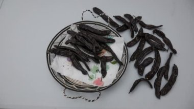 Beyaz arka planda kurumuş keçiboynuzu meyvesinin hareketsiz kalma süresi, tipik sonbahar. Keçiboynuzu, keçiboynuzu ve keçiboynuzu aynı meyveyle karıştırır. Yüksek kalite 4k görüntü