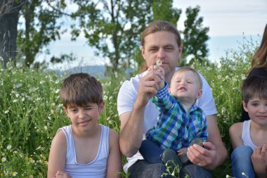 young boy and his father playing with a little son in the park