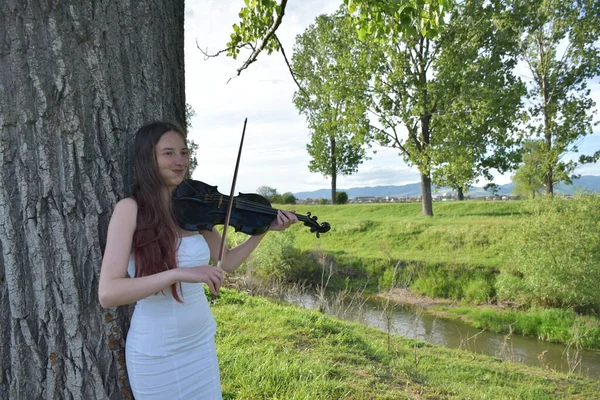 穿着白衣 拿着黑小提琴的女孩 — 图库照片
