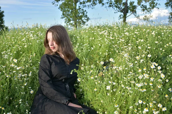 Siyah Elbiseli Bir Kız Çimlerin Üzerinde Oturuyor — Stok fotoğraf