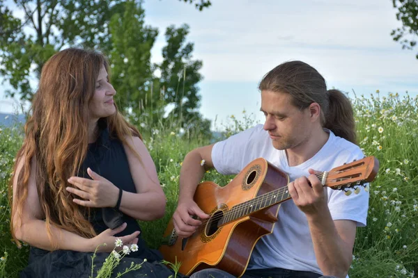 一个女人和一个拿着吉他的男人 — 图库照片