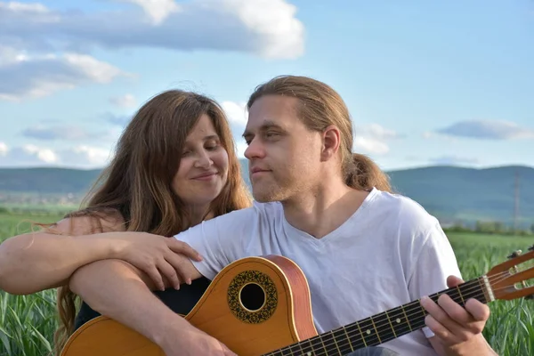 一个女人和一个拿着吉他的男人 — 图库照片