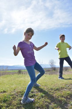Boy and girl having fun together on green field
