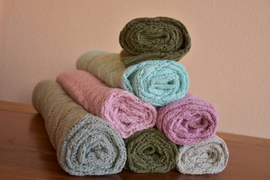 Rolls of knitted clothes stacked in pyramid on the table