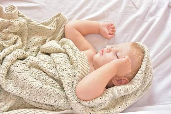 baby sleeping and knitted blanket